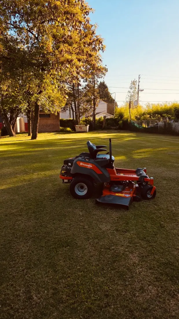 Minitractor de corte en parque al atardecer
